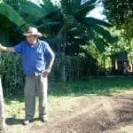 Ein Mann steht in einem Garten.