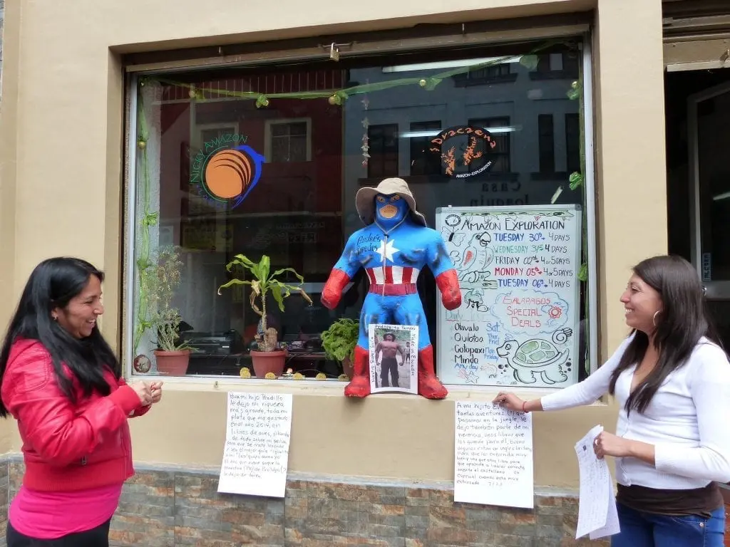 Quito, Ecuador, Stadtbesichtigung mit Kindern, alleine Reisen mit Kindern Zwei Frauen dekorieren für Silvester mit einer Puppe und Texten auf Papier