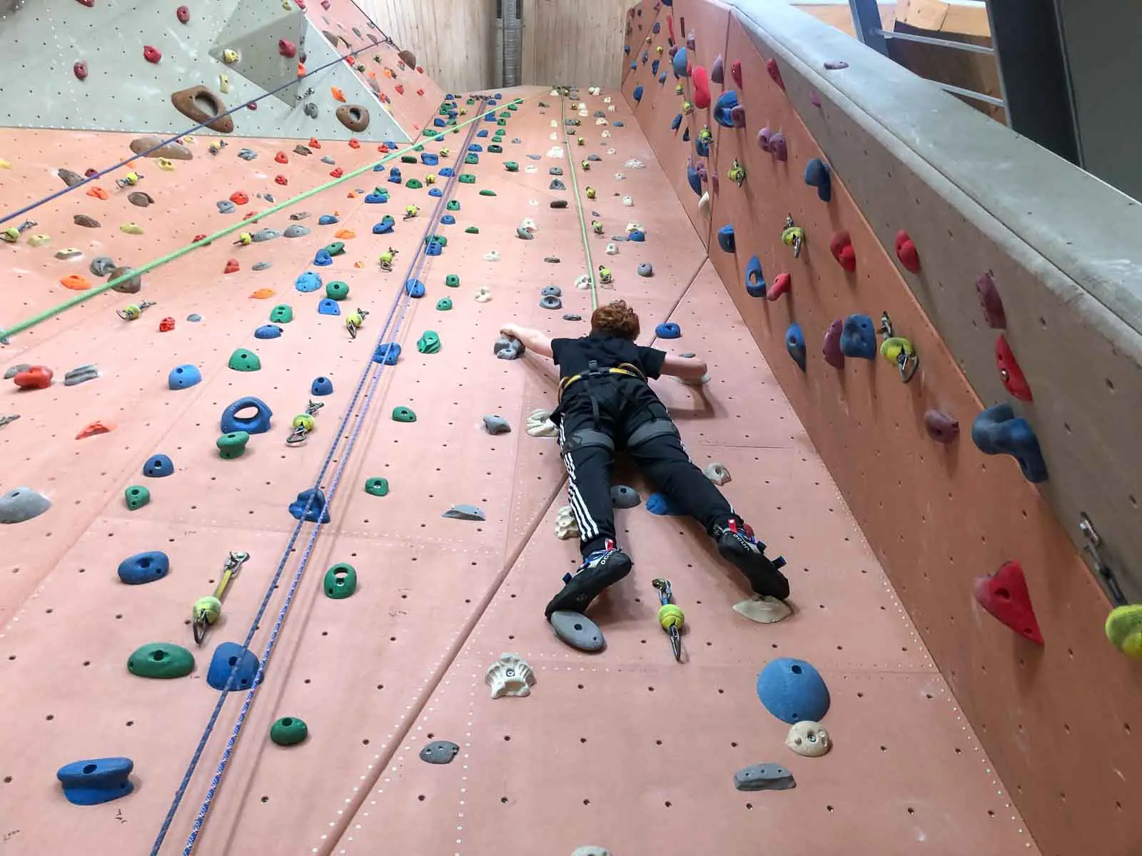 Kind an der hohen Kletterwand in der Kletterhalle Zuckerhut in Wunsiedel im Fichtelgebirge