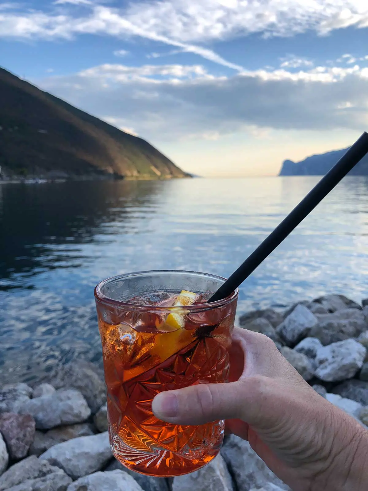Mit einem Aperol Sprizz am Ufer des Gardasees den Sonnenuntergang genießen.