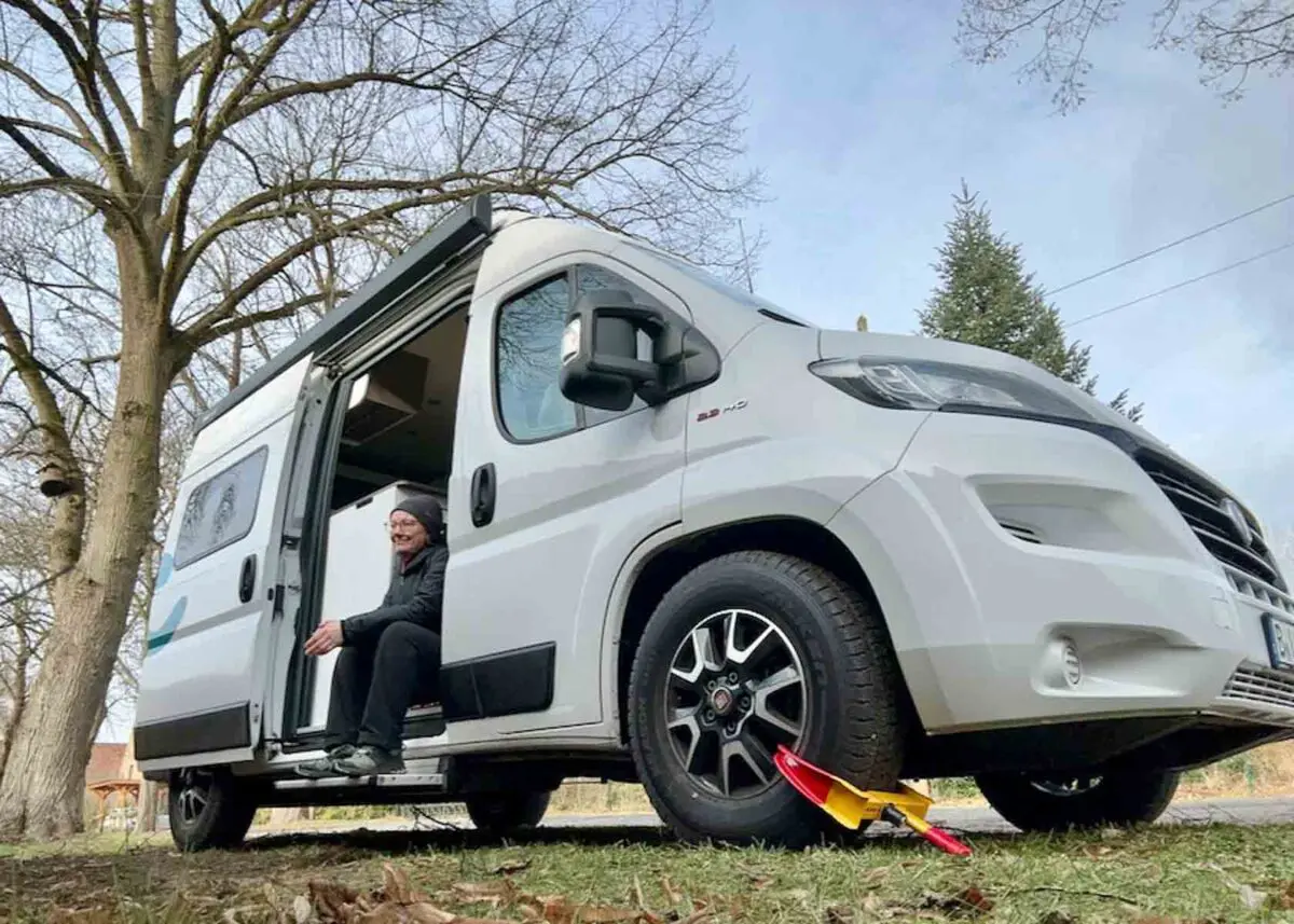 Frau sitzt in einem Wohnmobil mit Radkralle zum Diebstahlschutz