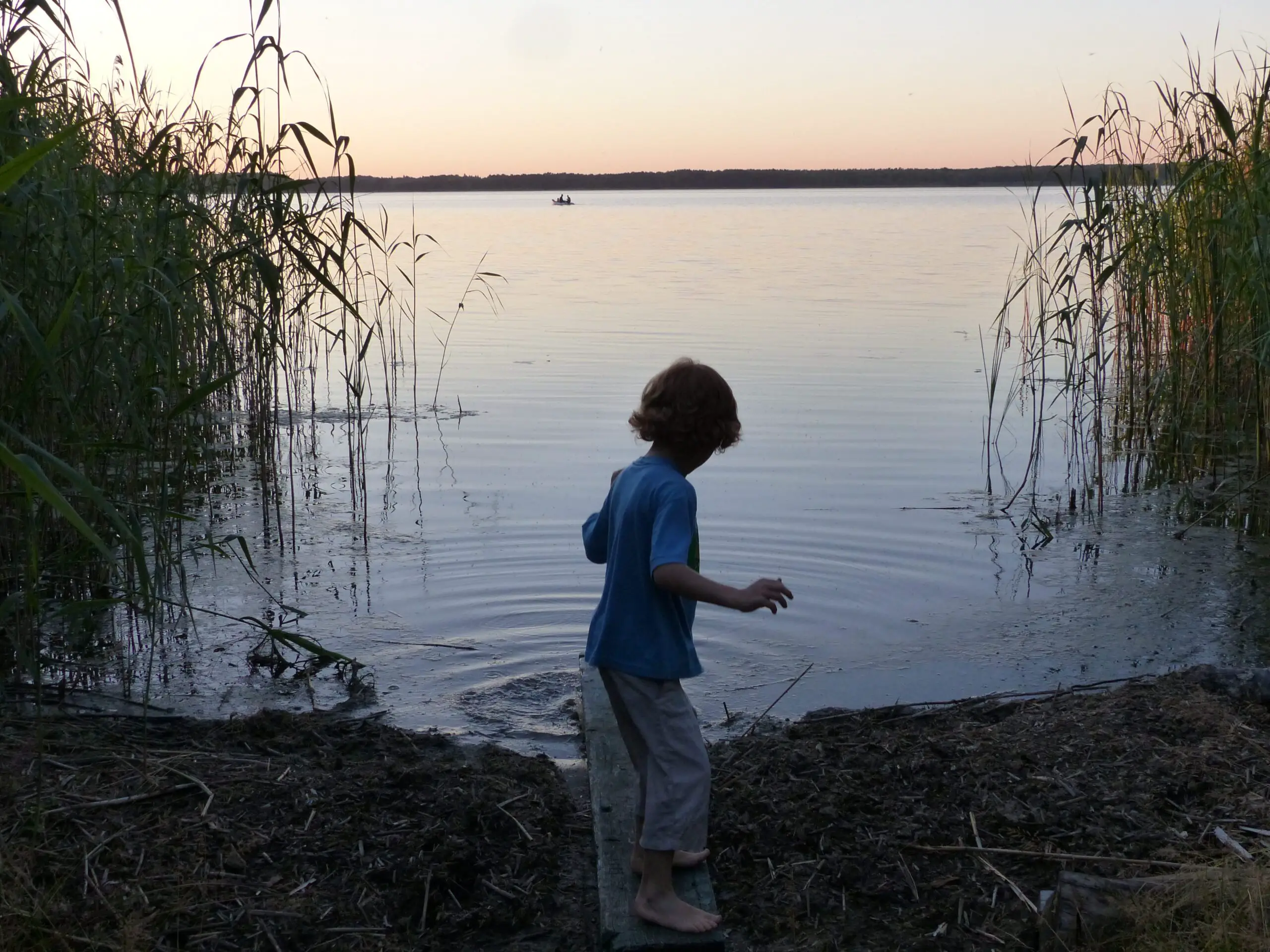 Kind spielt am See im Familienurlaub