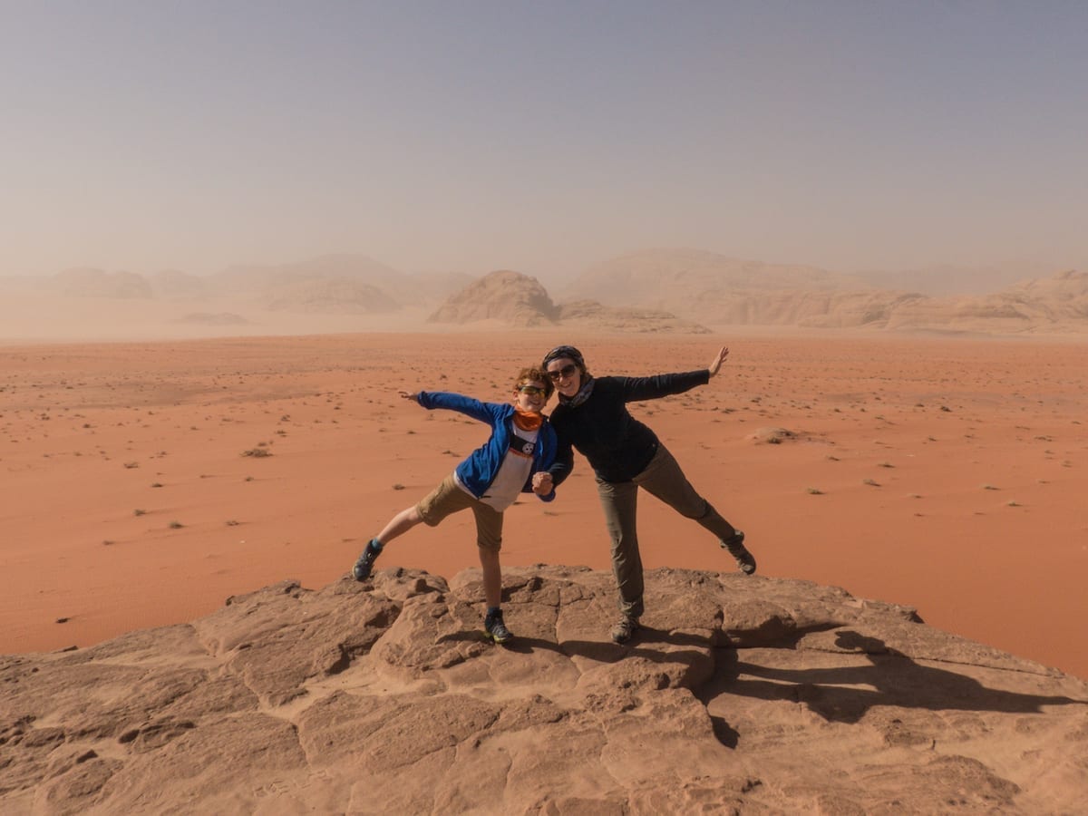 Mutter spielt mit Kind auf Felsen in der Wüste Wadi Rum in Jordanien bei einer Rundreise