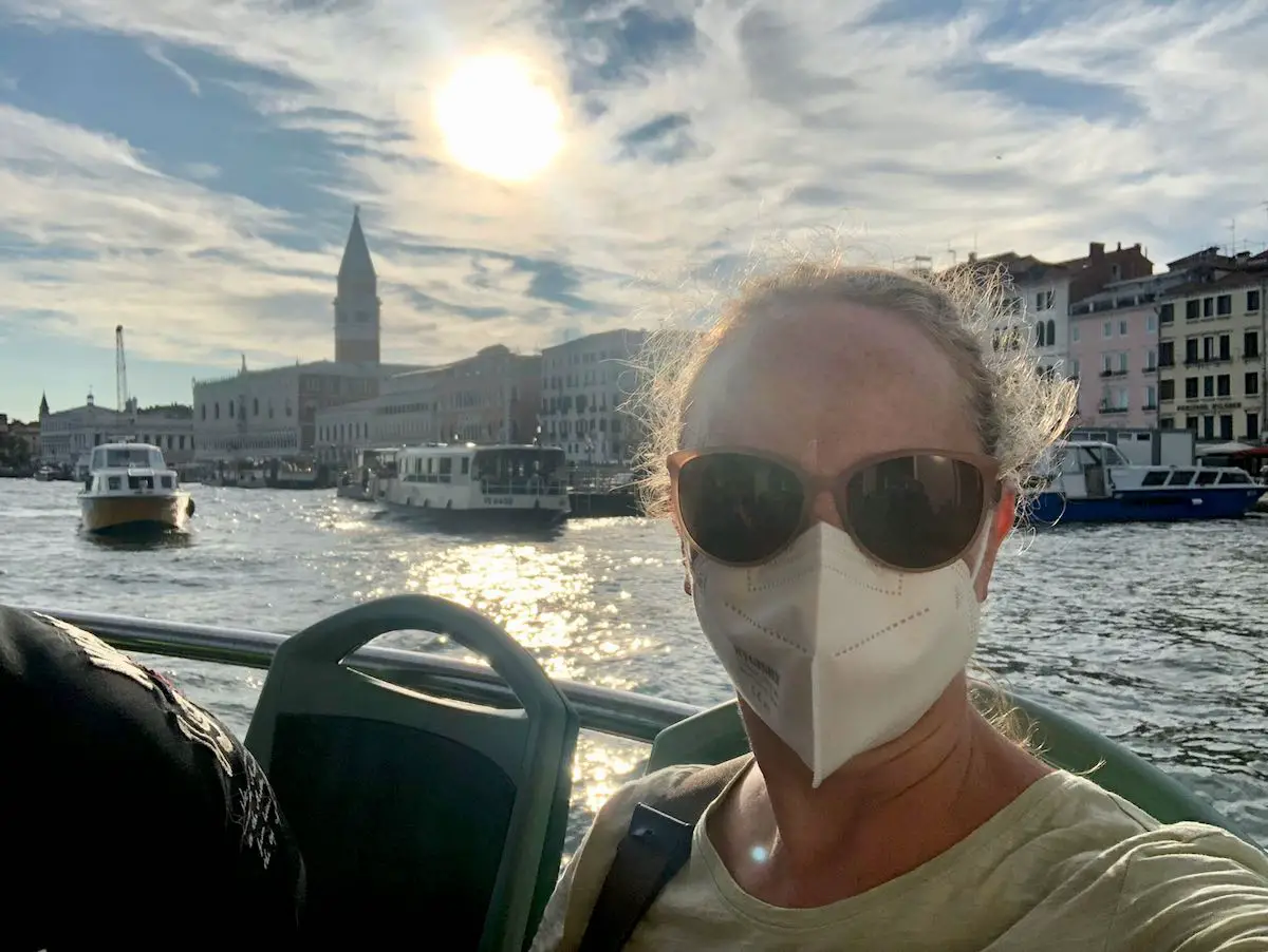 Mit Maske im Sonnneuntergang auf dem Vaporetto vor Venedig