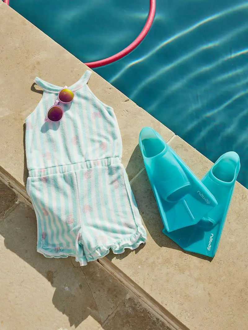 Badeanzug und Schwimmflossen für Kinder am Pool