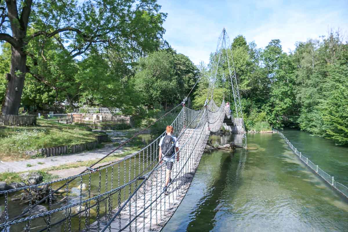Kind geht über eine Hängebrücke im Münchner Tierpark Hellabrunn