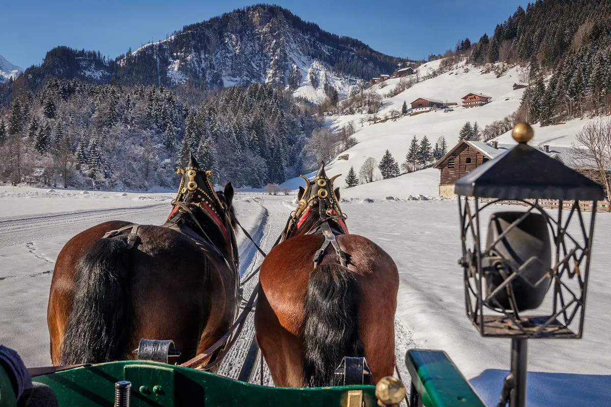 Pferdeschlitten mit Laterne in verschneiter Berglandschaft
