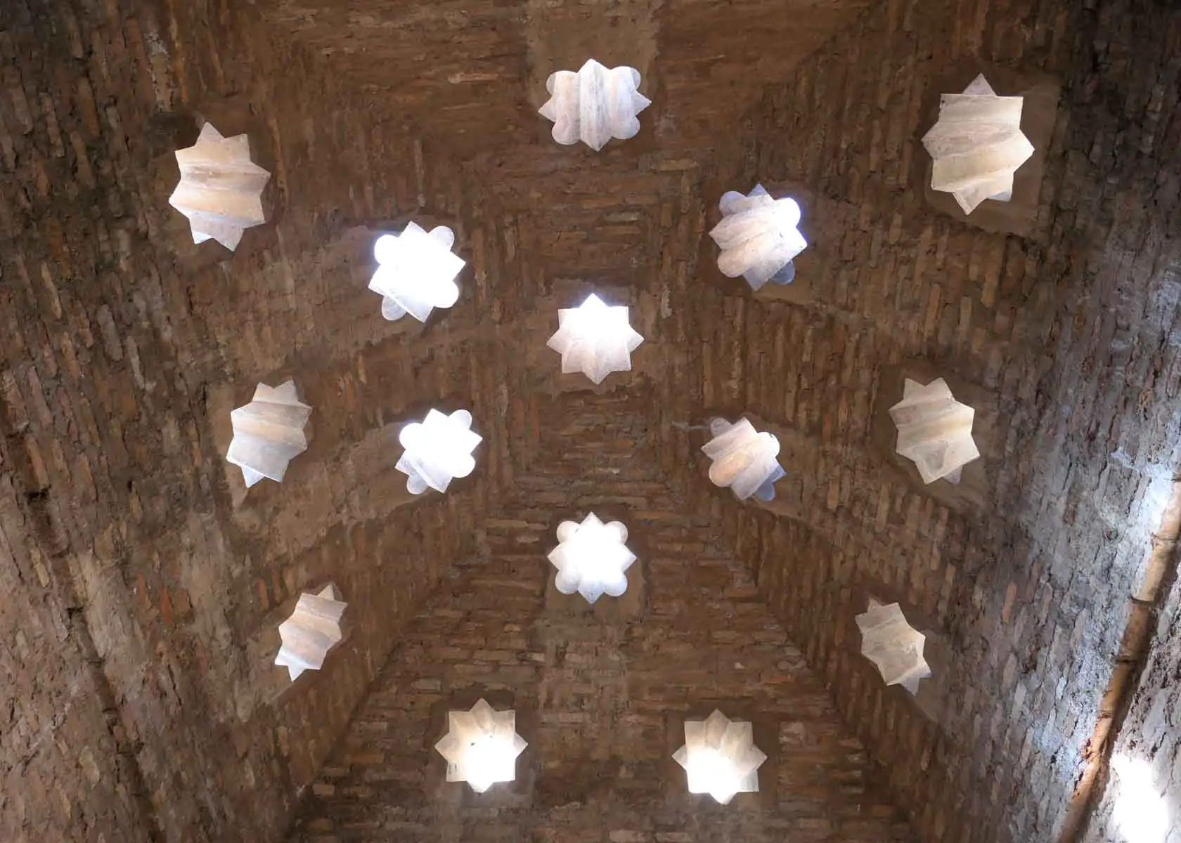 Decke mit sternförmigen Fenstern im arabischen Bad in der Medina der Alhambra