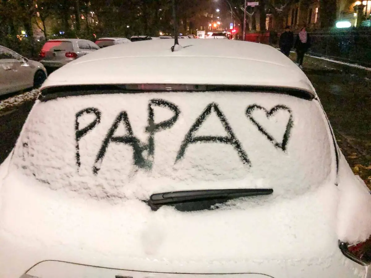Verschneites Auto - in den Schnee auf der Heckscheibe hat ein Kind "Papa" geschrieben und ein Herz gemalt