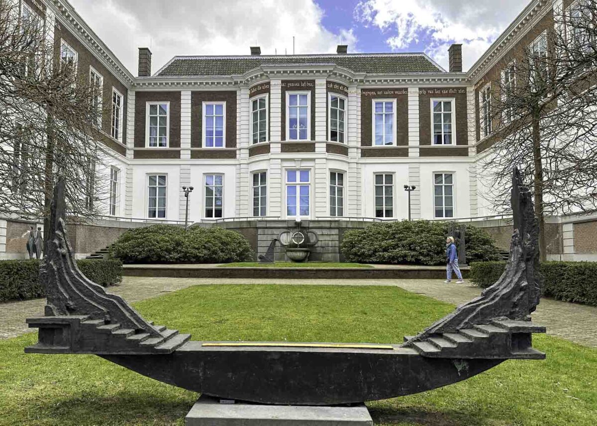 Skulptur in einem Park vor einem majestätischen historischen Gebäude in Den Haag 
