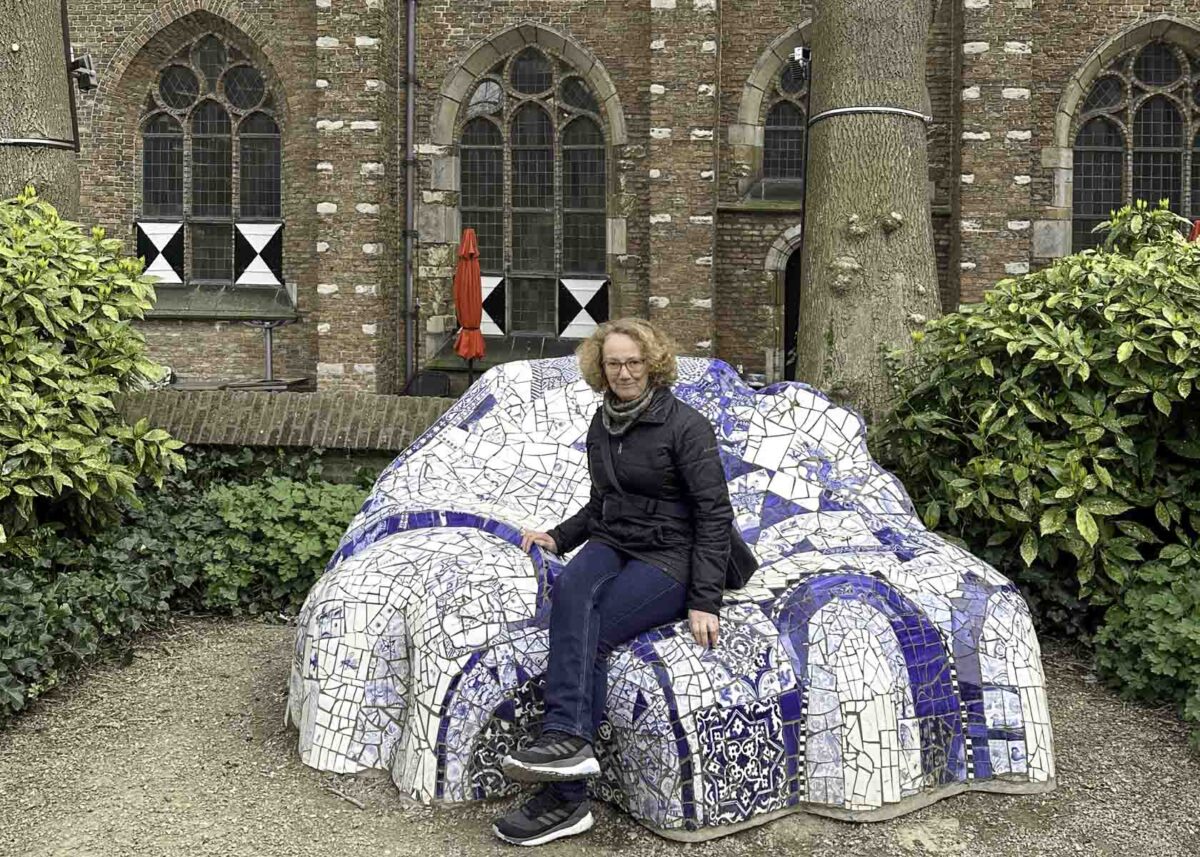 Frau auf einer Bank im Stil von Antonio Guadi aus Porzellan mit Delfter Blau vor der Oude Kerk in Delft