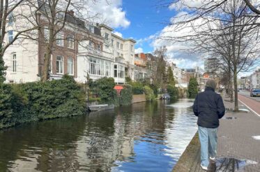 Teenager an einer Gracht mit schönen Altbau-Villen in Den Haag