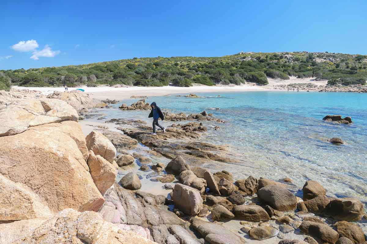 Wandern über Felsen auf Sardinien mit Kind am Strand