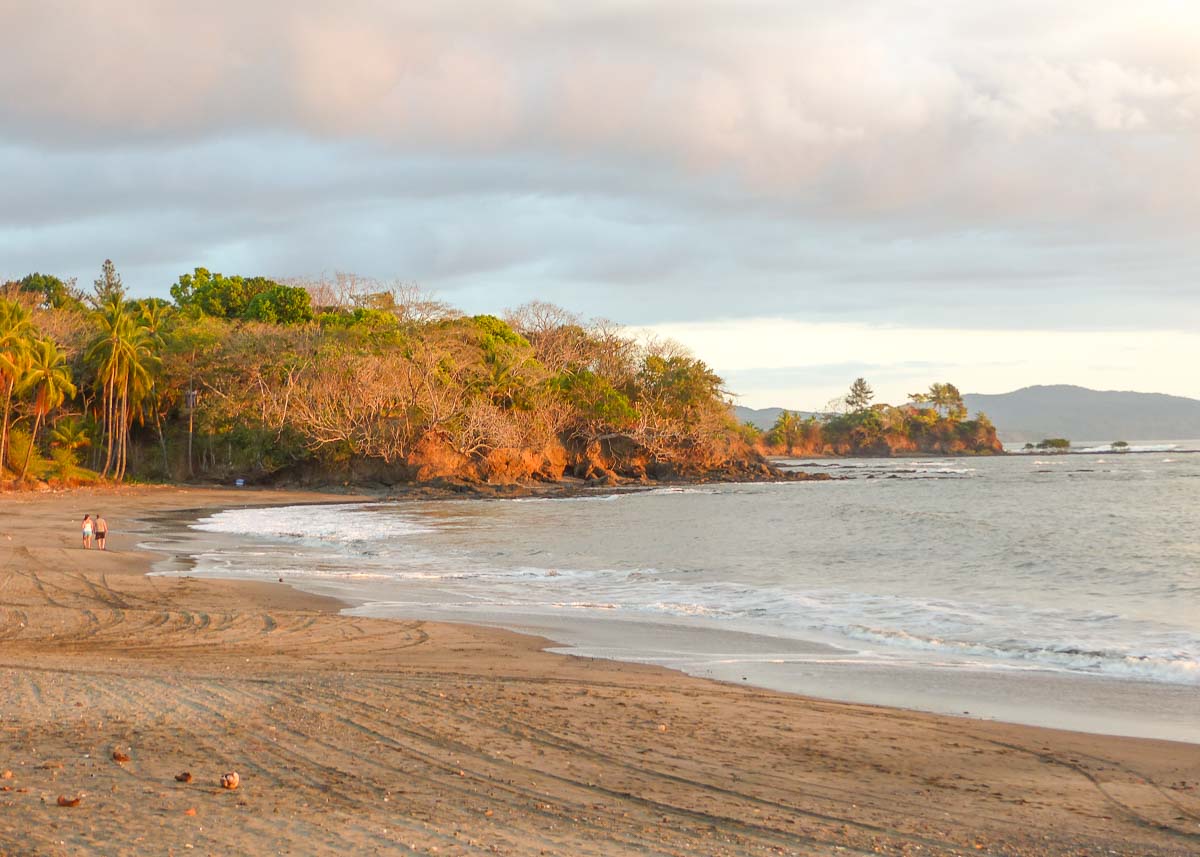 Wenn an der Küste von Panama Strand mit mittelhellem Sand im Abendrot glüht, wirkt auch die tropische Vegetation im Hintergrund rötlich.