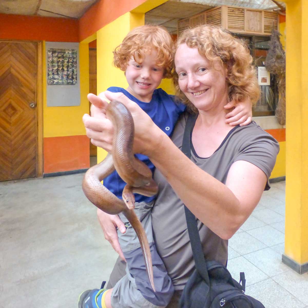 Im Serpentarium Eco Zoo von El Arenal hält eine Mutter ihr Kind auf dem Arm und in der anderen Hand eine Schlange.